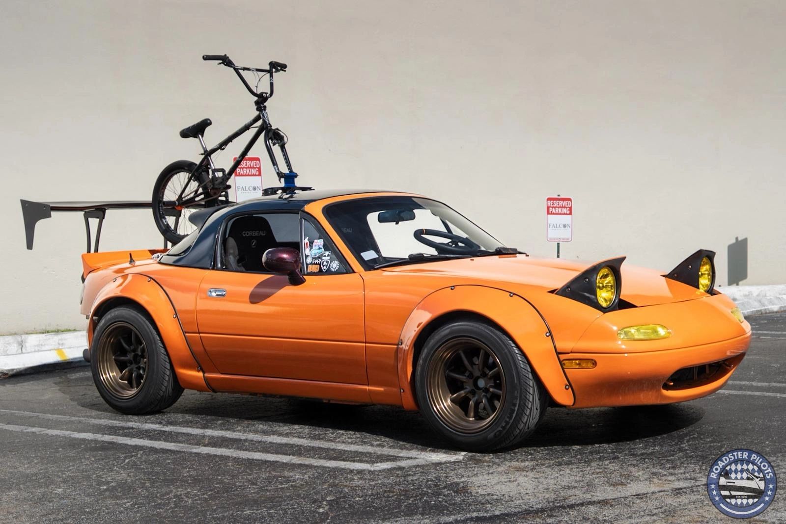 Orange Miata carrying a bicycle